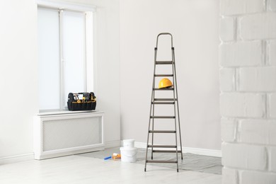 Ladder, decorator's tools and box with instruments in room