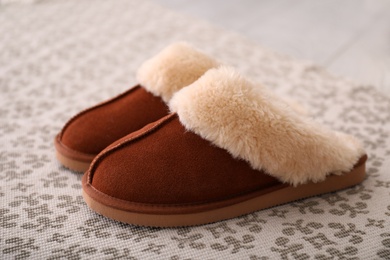 Photo of Brown warm slippers on floor in room