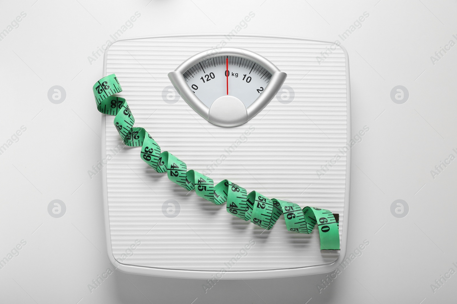 Photo of Scales and measuring tape on white background, top view