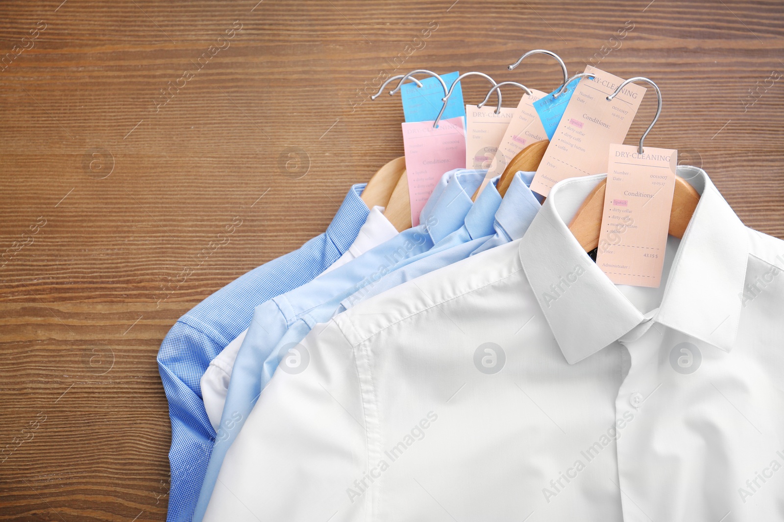 Photo of Clean clothes after dry-cleaning on table