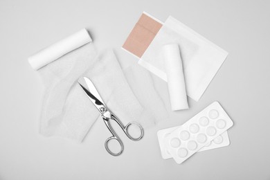 Photo of Bandage rolls and medical supplies on white background, flat lay
