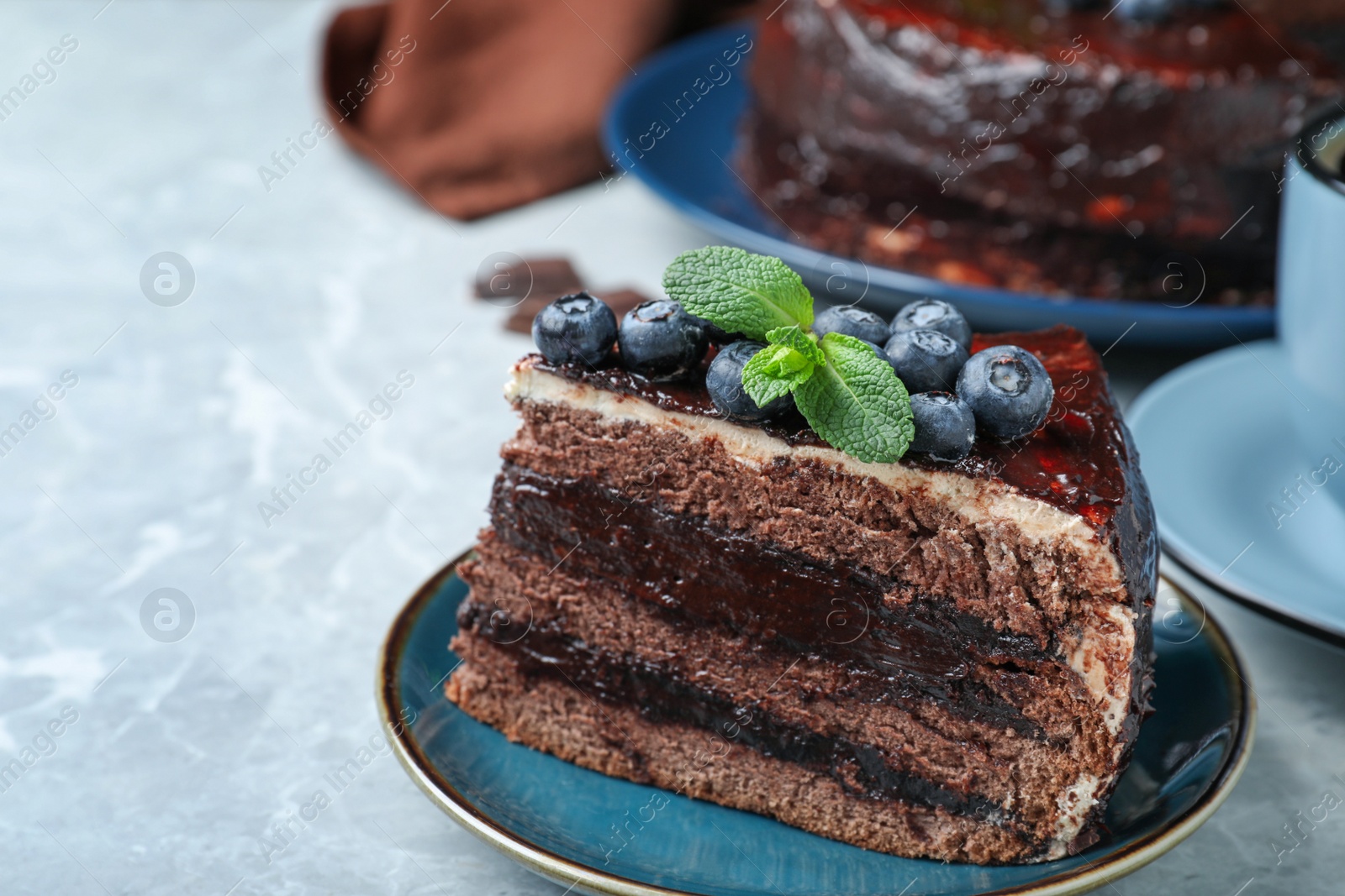 Photo of Tasty chocolate cake with berries on grey marble table