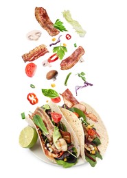 Image of Delicious tacos. Ingredients falling into tortillas on white background