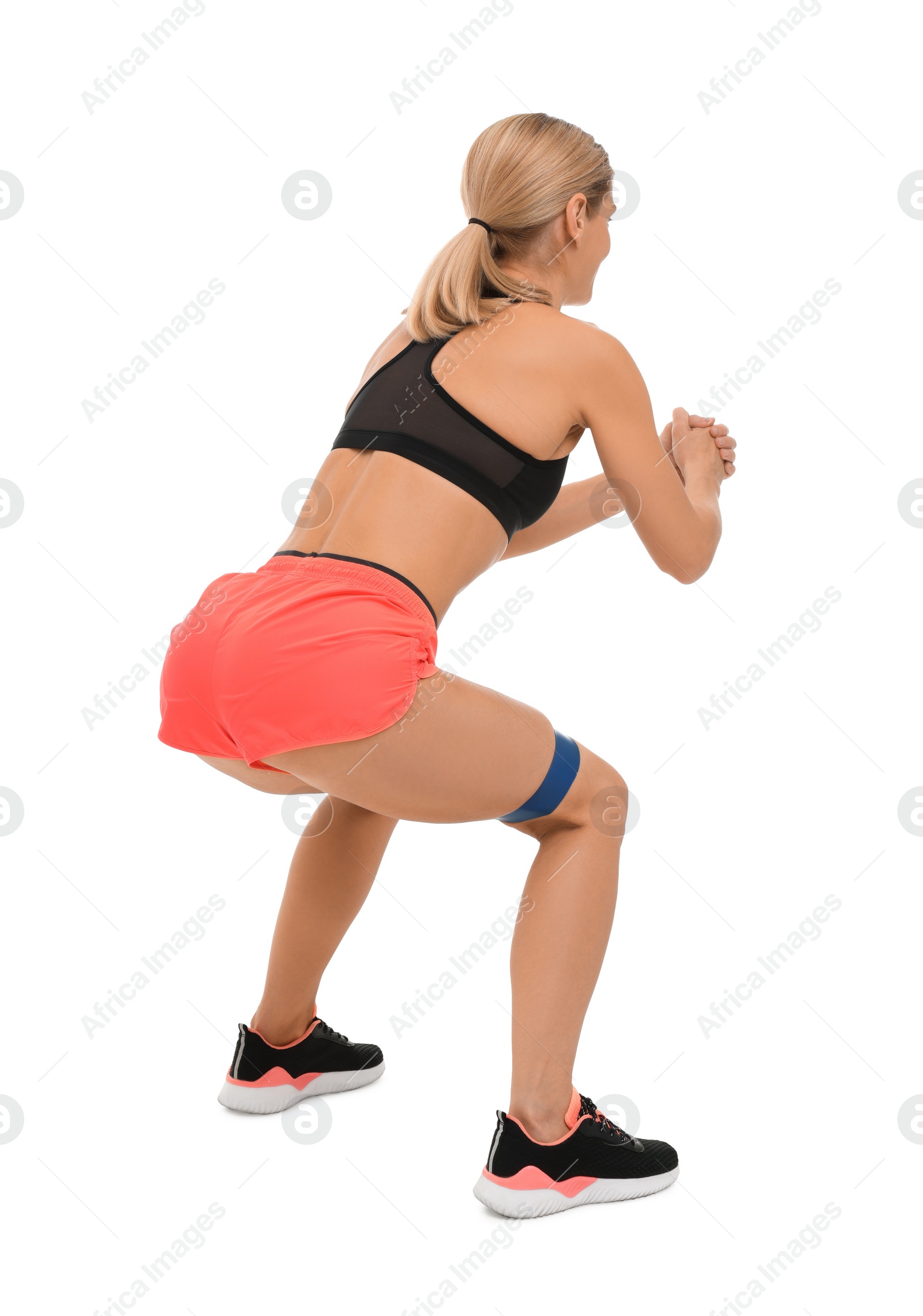 Photo of Woman exercising with elastic resistance band on white background, back view