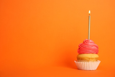 Birthday cupcake with candle on orange background, space for text