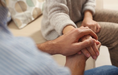 Photo of Man comforting woman, closeup of hands. Help and support concept