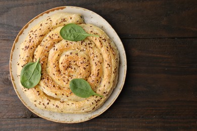 Photo of Delicious puff pastry with spinach on wooden table, top view. Space for text