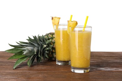 Tasty pineapple smoothie and fresh fruit on wooden table against white background