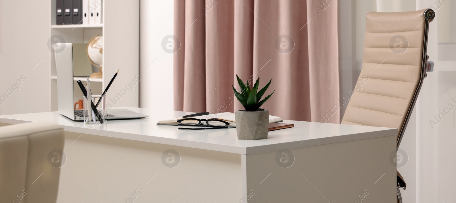 Photo of Cozy receptionist workspace with laptop on desk in office