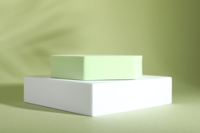 Presentation of product. Podiums and shadows on light green background. Space for text