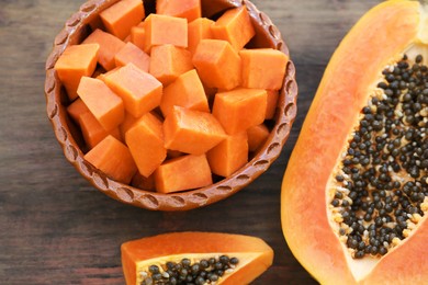 Tasty ripe cut papaya fruits on wooden table, flat lay