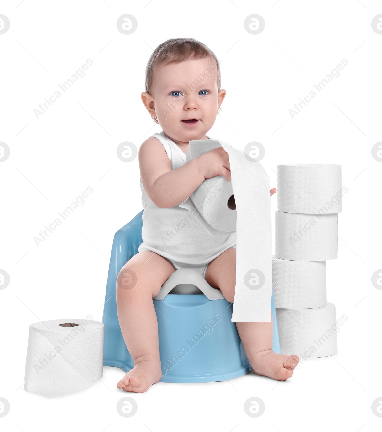 Photo of Little child sitting on baby potty and stack of toilet paper rolls against white background