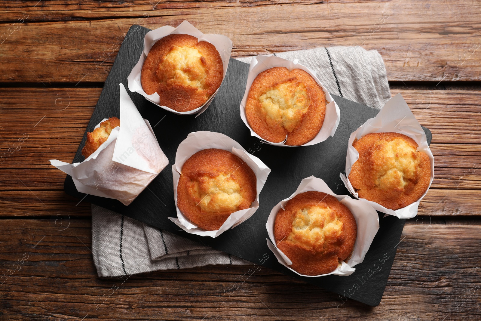 Photo of Delicious sweet muffins on wooden table, top view