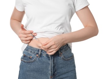 Photo of Diabetes. Woman making insulin injection into her belly on white background, closeup