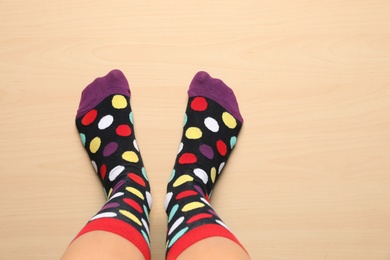 Photo of Woman wearing stylish socks standing on floor, top view. Space for design