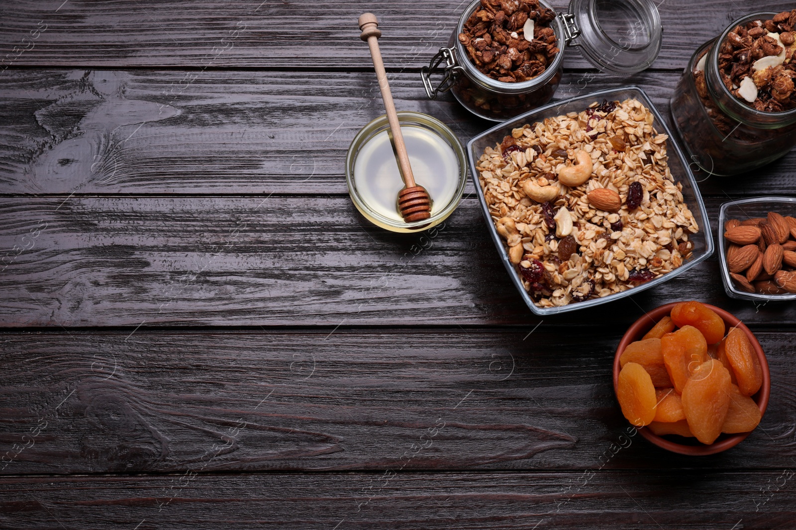 Photo of Tasty granola served with nuts and dry fruits on wooden table, flat lay. Space for text