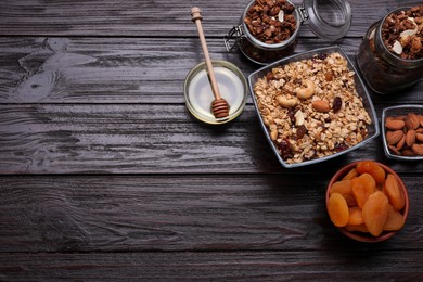 Photo of Tasty granola served with nuts and dry fruits on wooden table, flat lay. Space for text