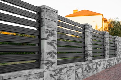 Beautiful stone fence with iron railing near pathway outdoors