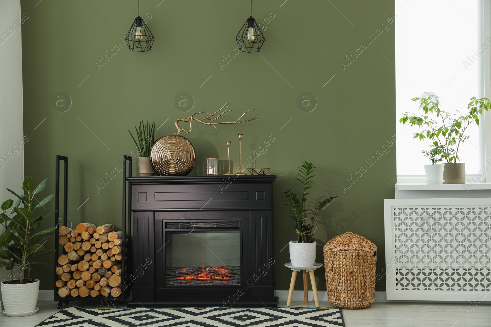 Photo of Beautiful fireplace, different decor and firewood in living room. Interior design