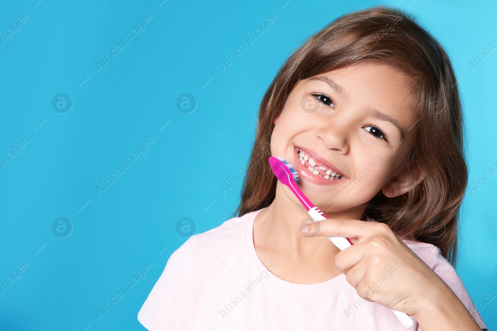 Photo of Portrait of little girl with toothbrush on color background. Space for text