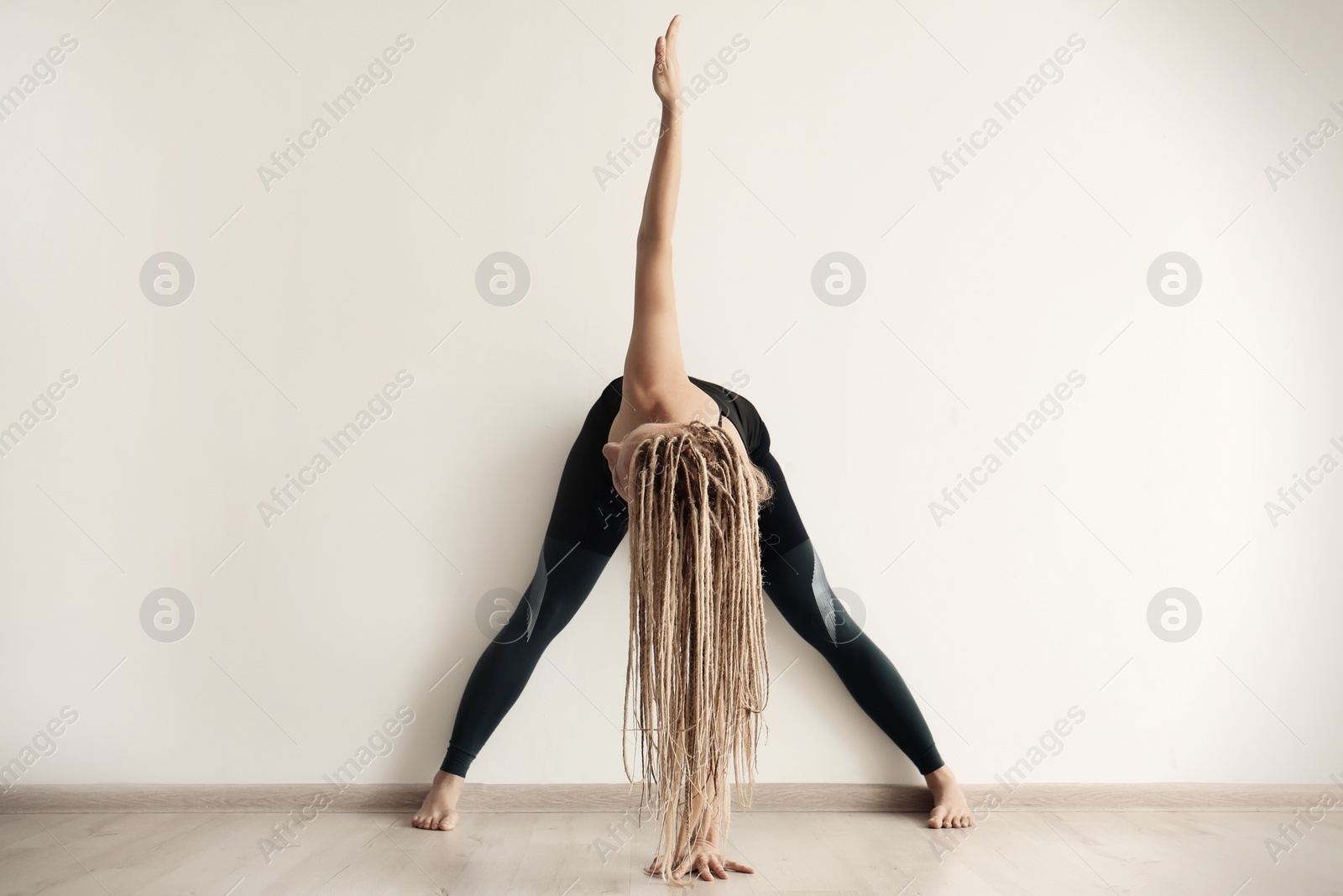 Photo of Young woman practicing yoga indoors