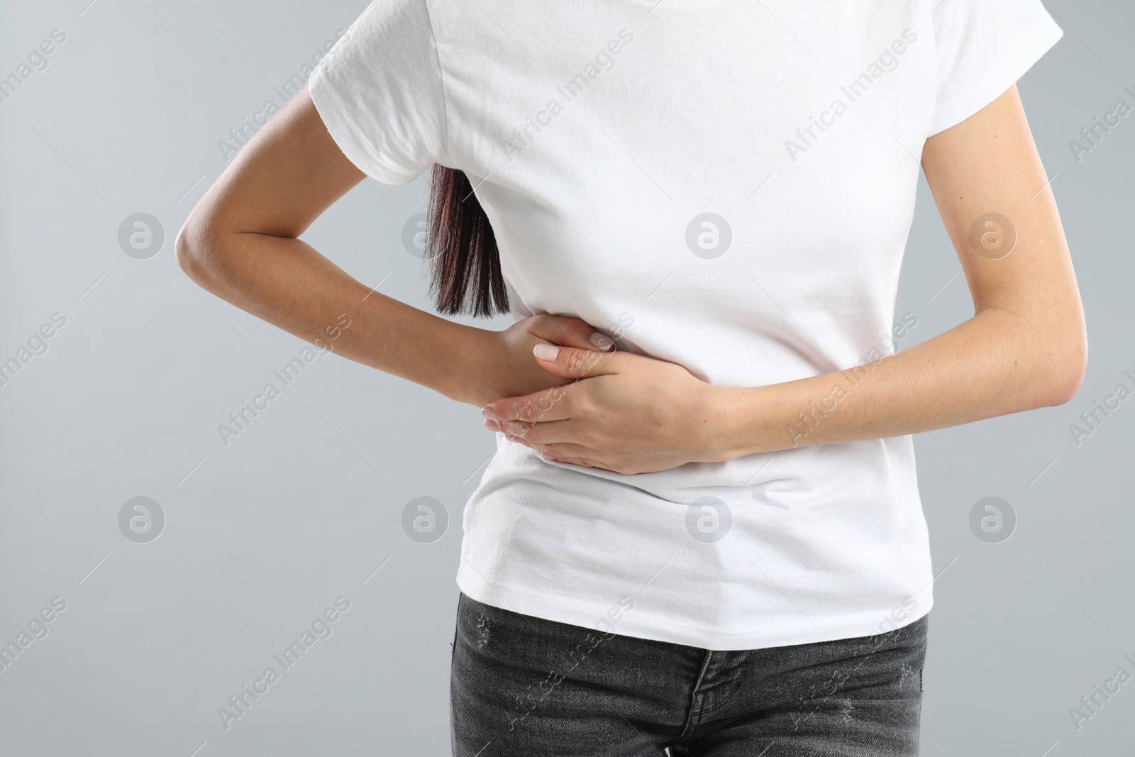 Photo of Woman suffering from liver pain on grey background, closeup