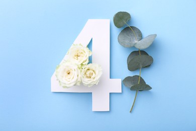 Photo of Paper number 4, beautiful flowers and eucalyptus branch on light blue background, top view