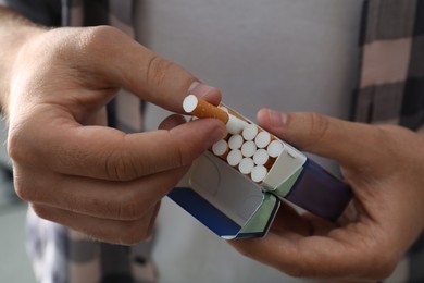 Man taking cigarette out of pack, closeup