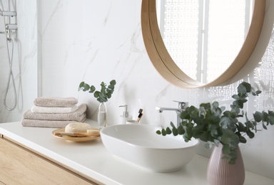 Photo of Fresh eucalyptus branches and bathroom items on countertop