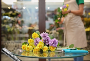 Photo of Beautiful bouquet on table in flower shop. Florist's workplace