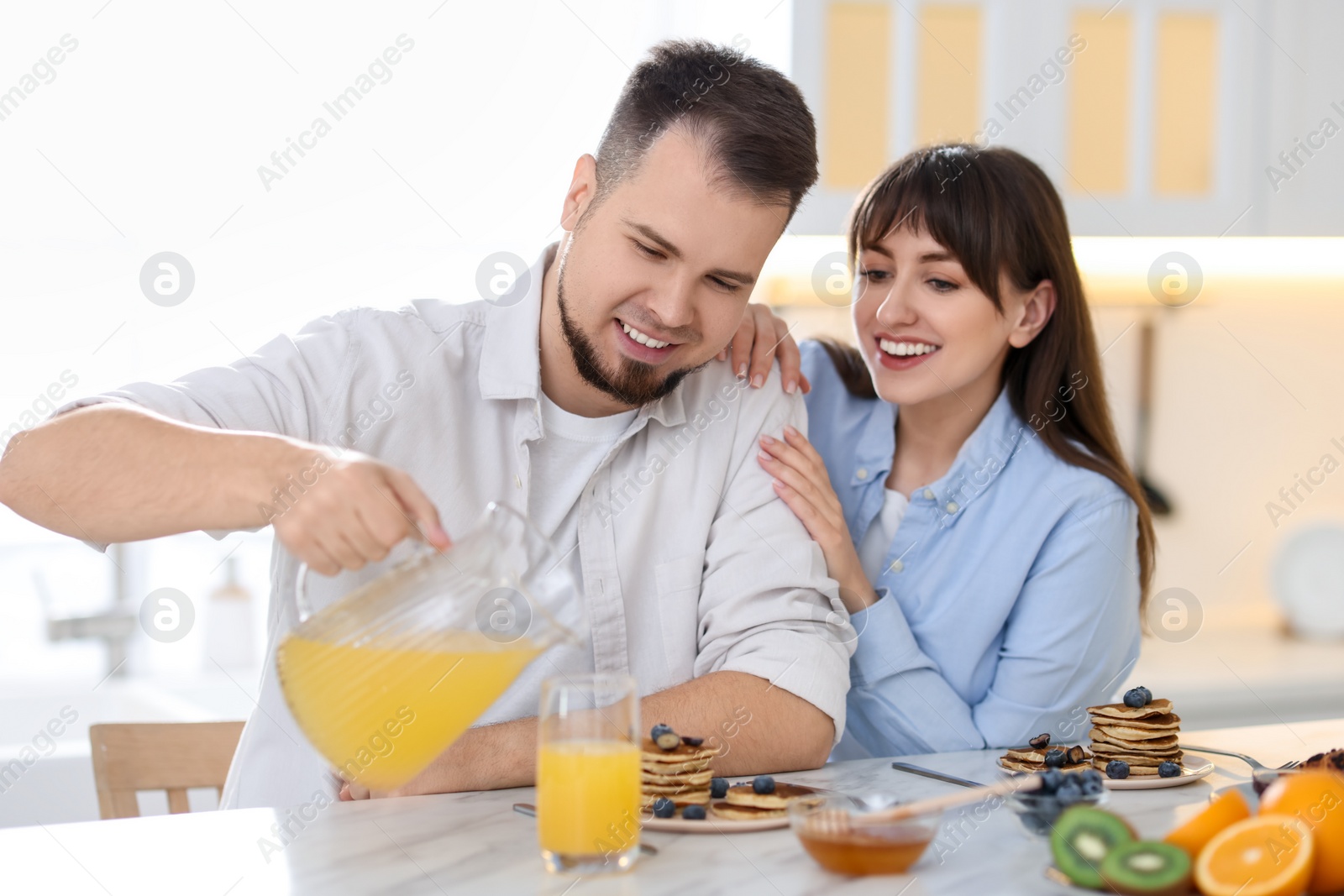 Photo of Happy couple having tasty breakfast at home