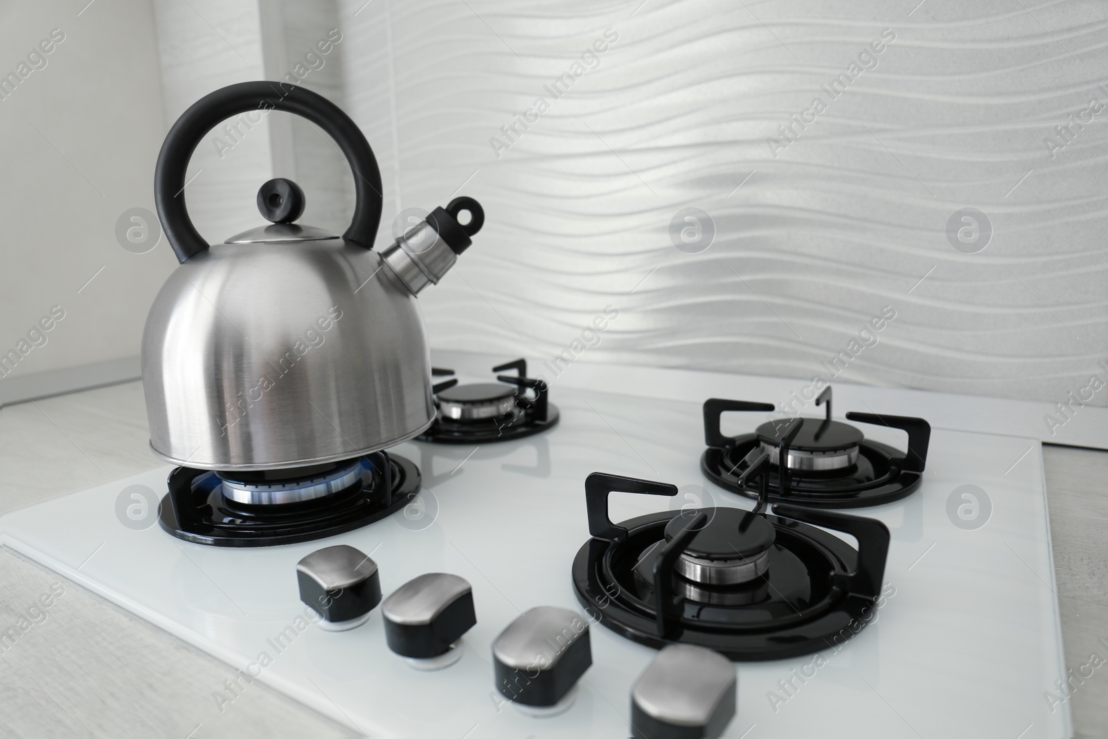 Photo of Kettle on modern gas stove in kitchen