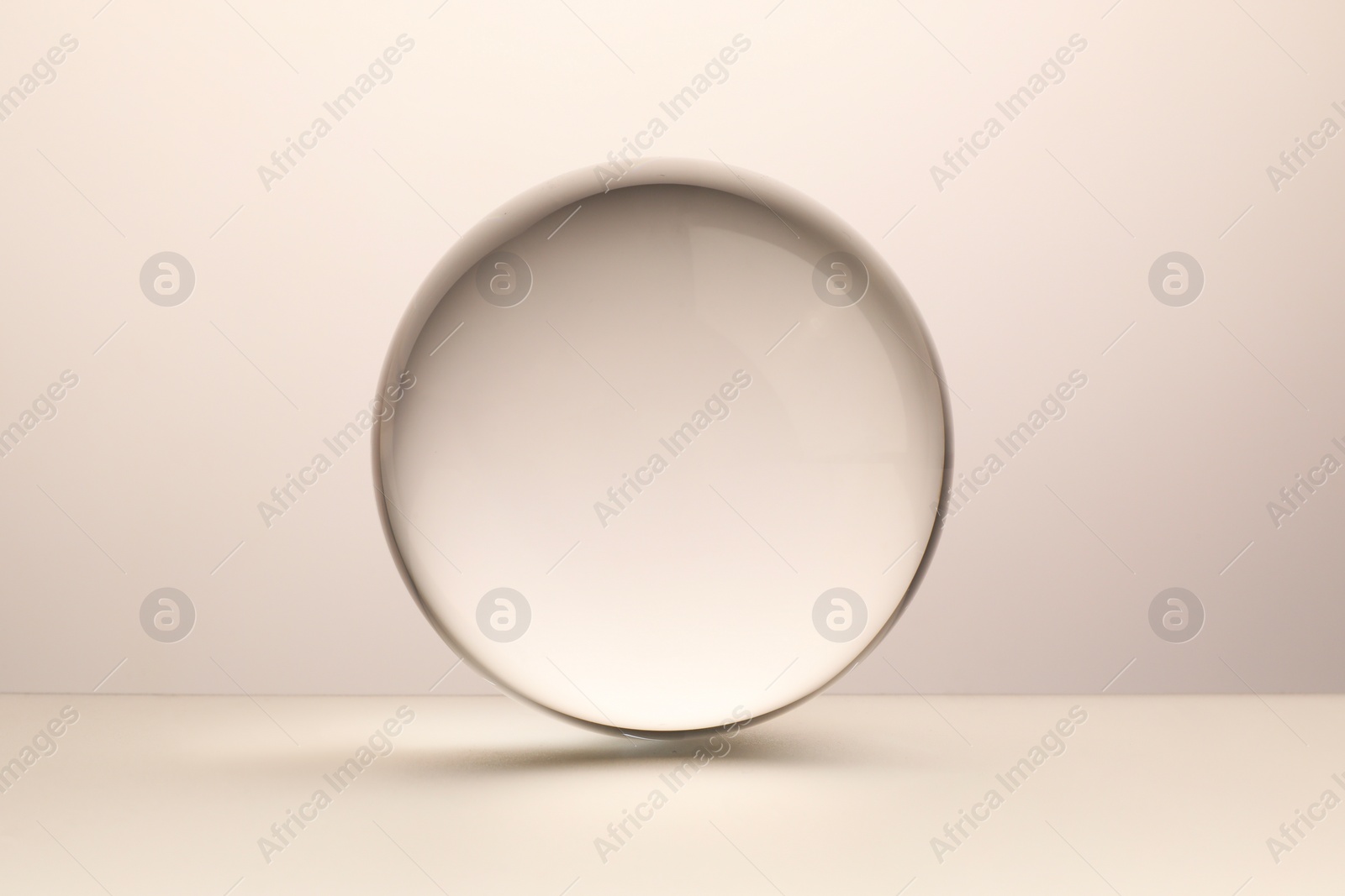 Photo of Transparent glass ball on light grey background