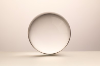 Photo of Transparent glass ball on light grey background