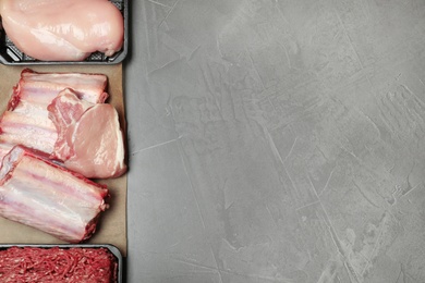 Photo of Flat lay composition with fresh raw meat and space for text on gray background