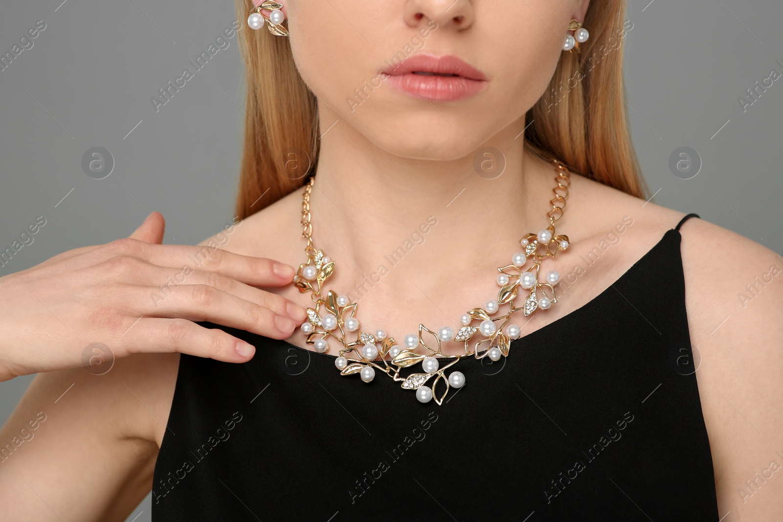 Photo of Woman with elegant jewelry on gray background, closeup