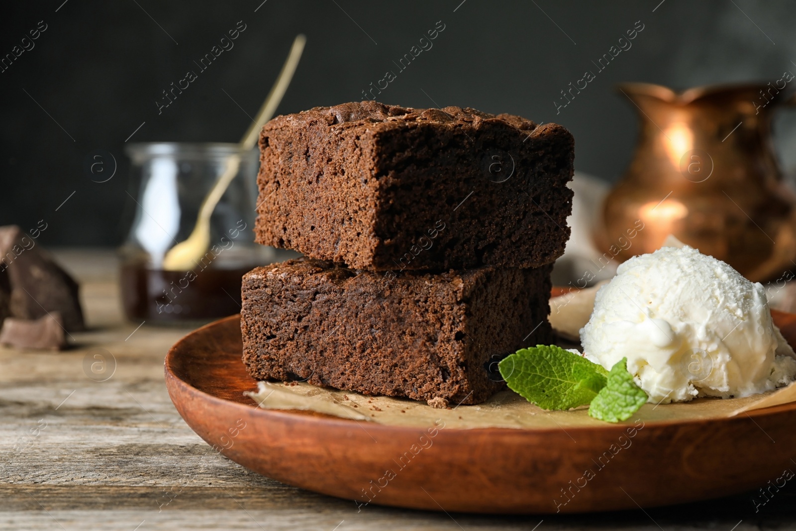 Photo of Plate with fresh brownies and ice-cream on table. Delicious chocolate pie