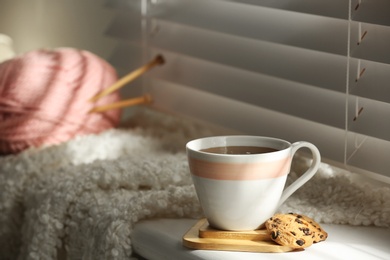 Photo of Cup of hot winter drink and cookies on windowsill indoors. Space for text