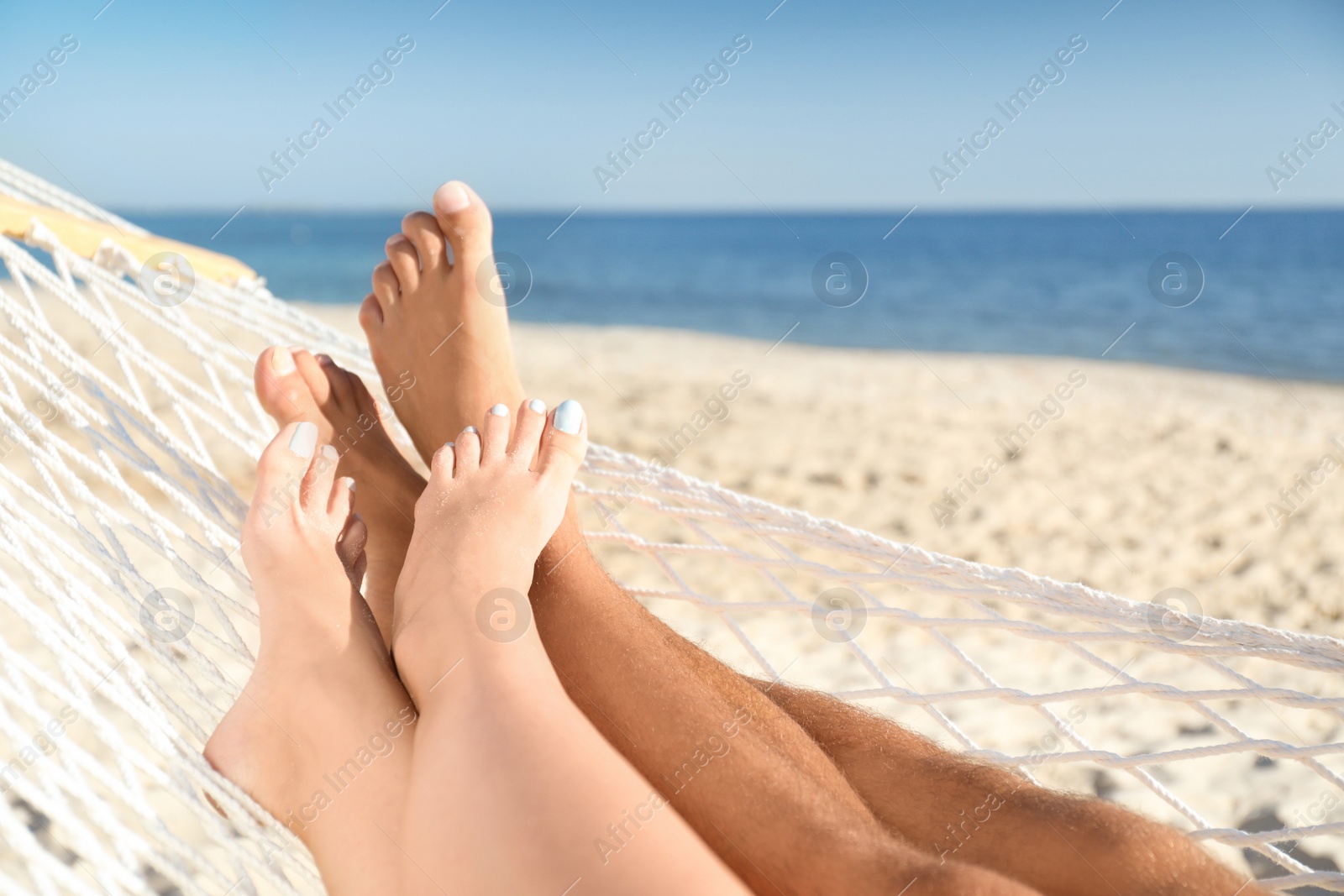 Photo of Couple relaxing in hammock on beach, closeup