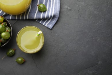 Photo of Tasty gooseberry juice on black table, flat lay. Space for text