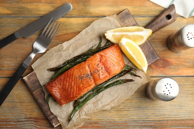 Photo of Tasty cooked salmon and vegetables served on wooden table, flat lay. Healthy meals from air fryer