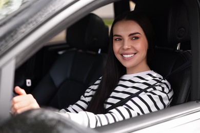 Woman with safety seat belt driving her modern car