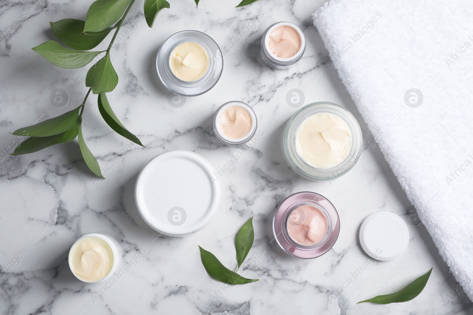 Photo of Flat lay composition with hand cream jars on marble background