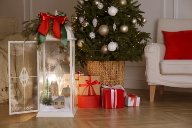 Beautiful lantern with festive composition near Christmas tree indoors