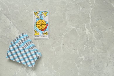 Photo of The Wheel of Fortune and other tarot cards on light grey marble table, flat lay. Space for text