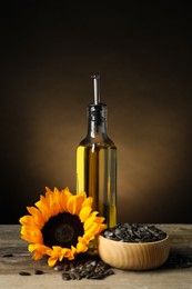 Sunflower cooking oil, seeds and yellow flower on light grey table