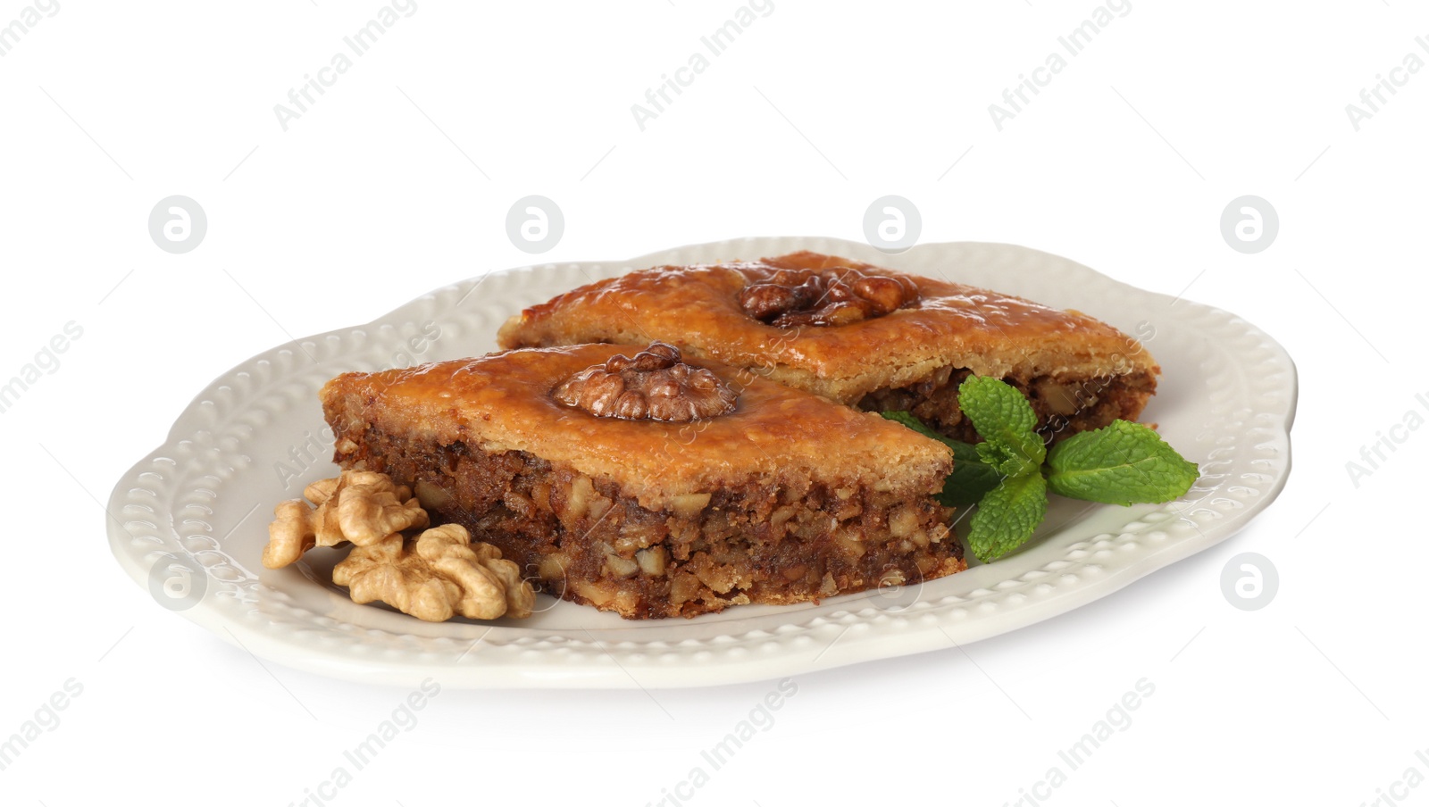 Photo of Plate of delicious honey baklava with walnuts on white background