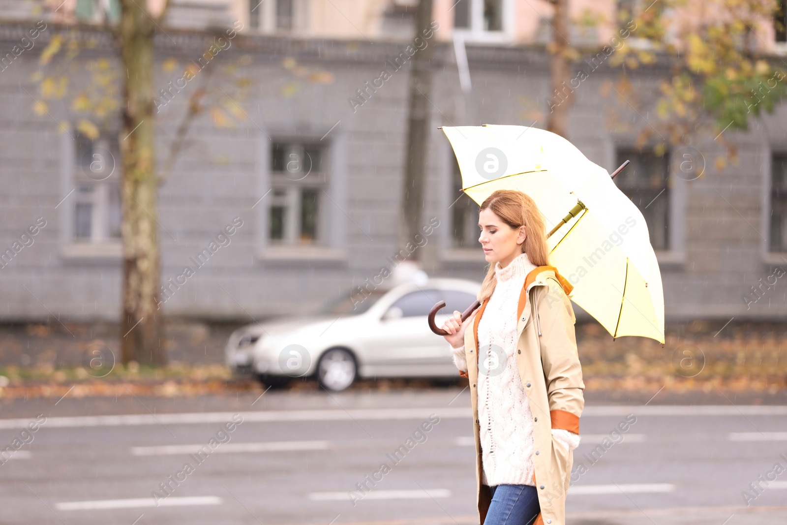 Photo of Woman with umbrella in city on autumn rainy day