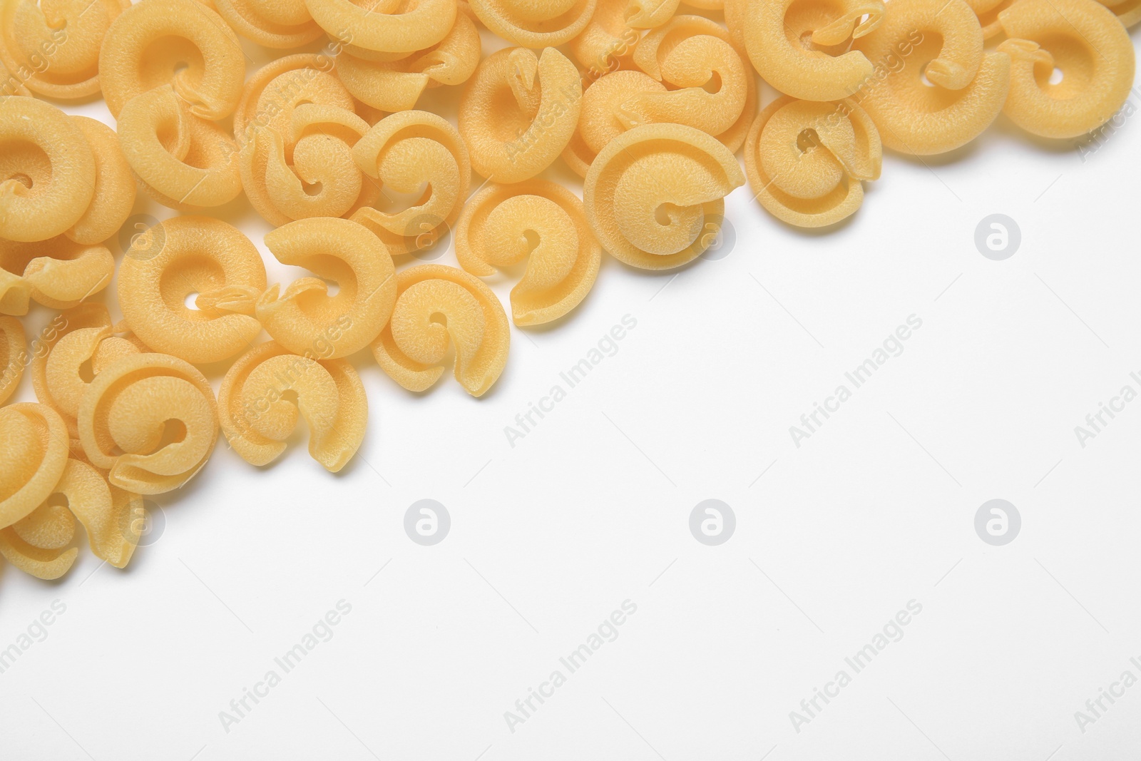 Photo of Raw dischi volanti pasta on white background, top view. Space for text