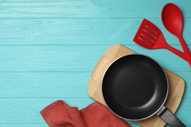 Photo of Set of modern cooking utensils on light blue wooden table, flat lay. Space for text